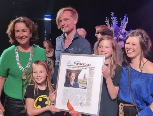 Family posing on stage with father winning an award.