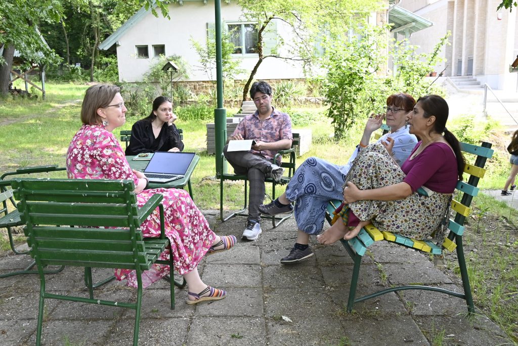 The English is correct, but it can be slightly improved for clarity and flow:

"People sitting outside, engrossed in a conversation.