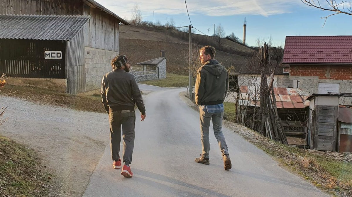 Men walking in village.