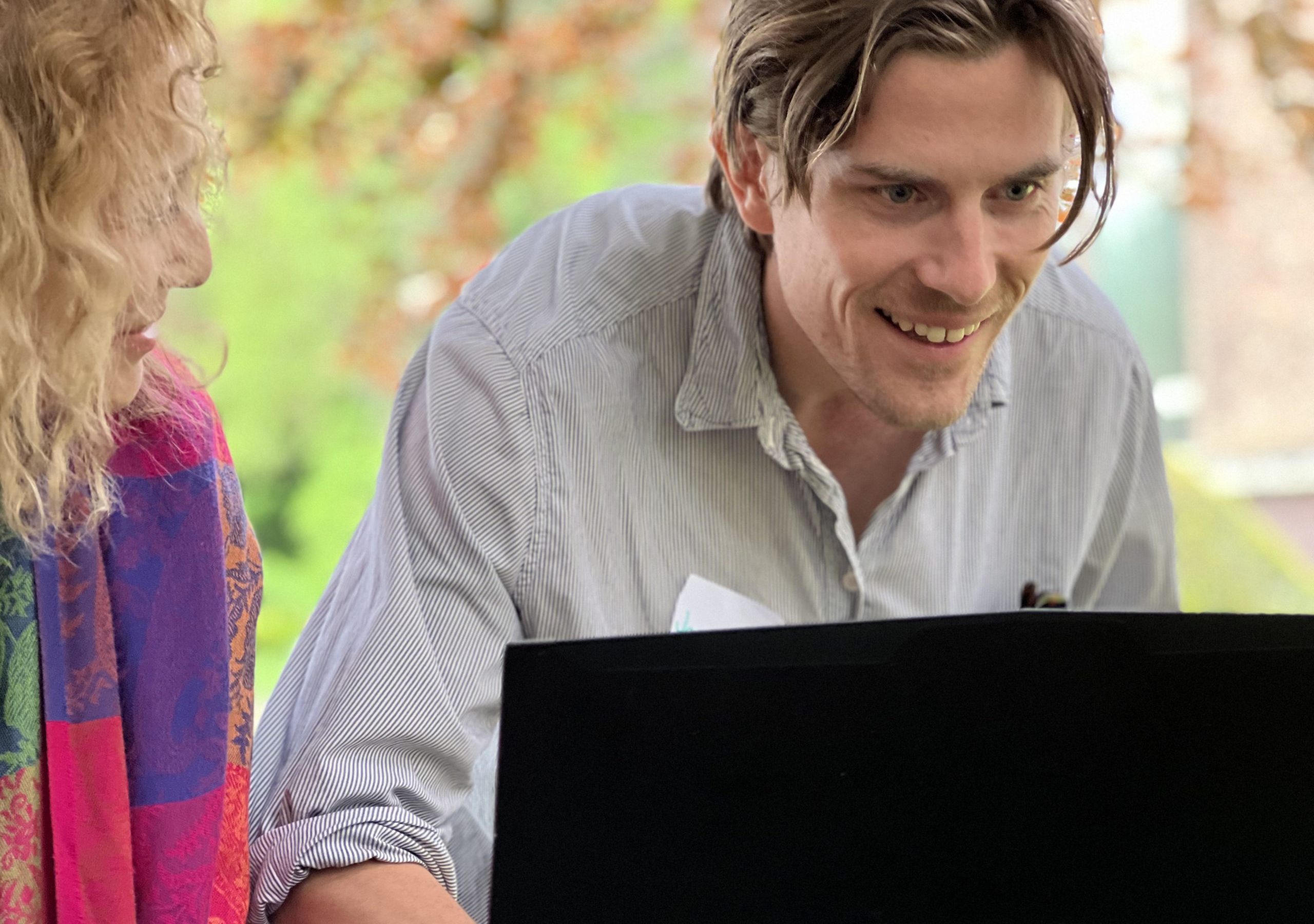 A man and and a woman fixing with a computer.